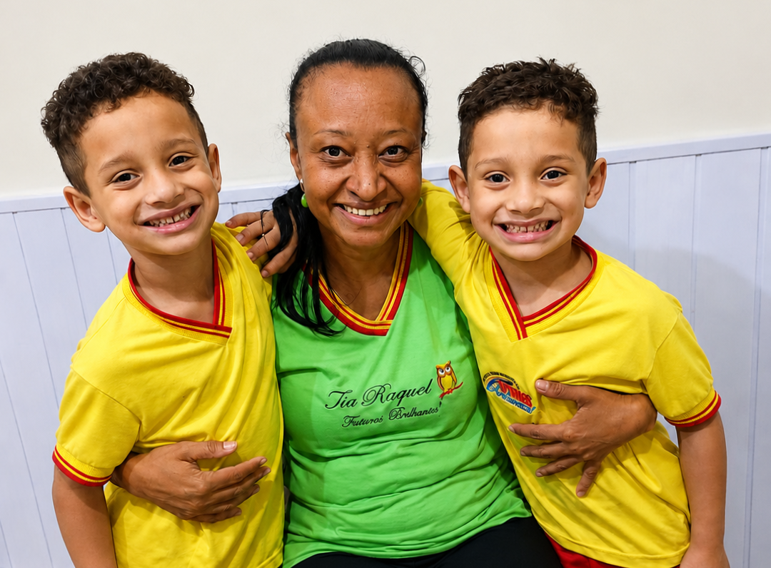 Tia Raquel abraçando dois alunos sorridentes da escola Futuros Brilhantes
